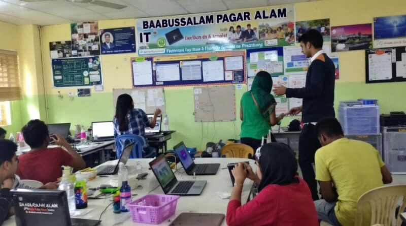 Kelas dinamis dengan siswa menggunakan teknologi modern.